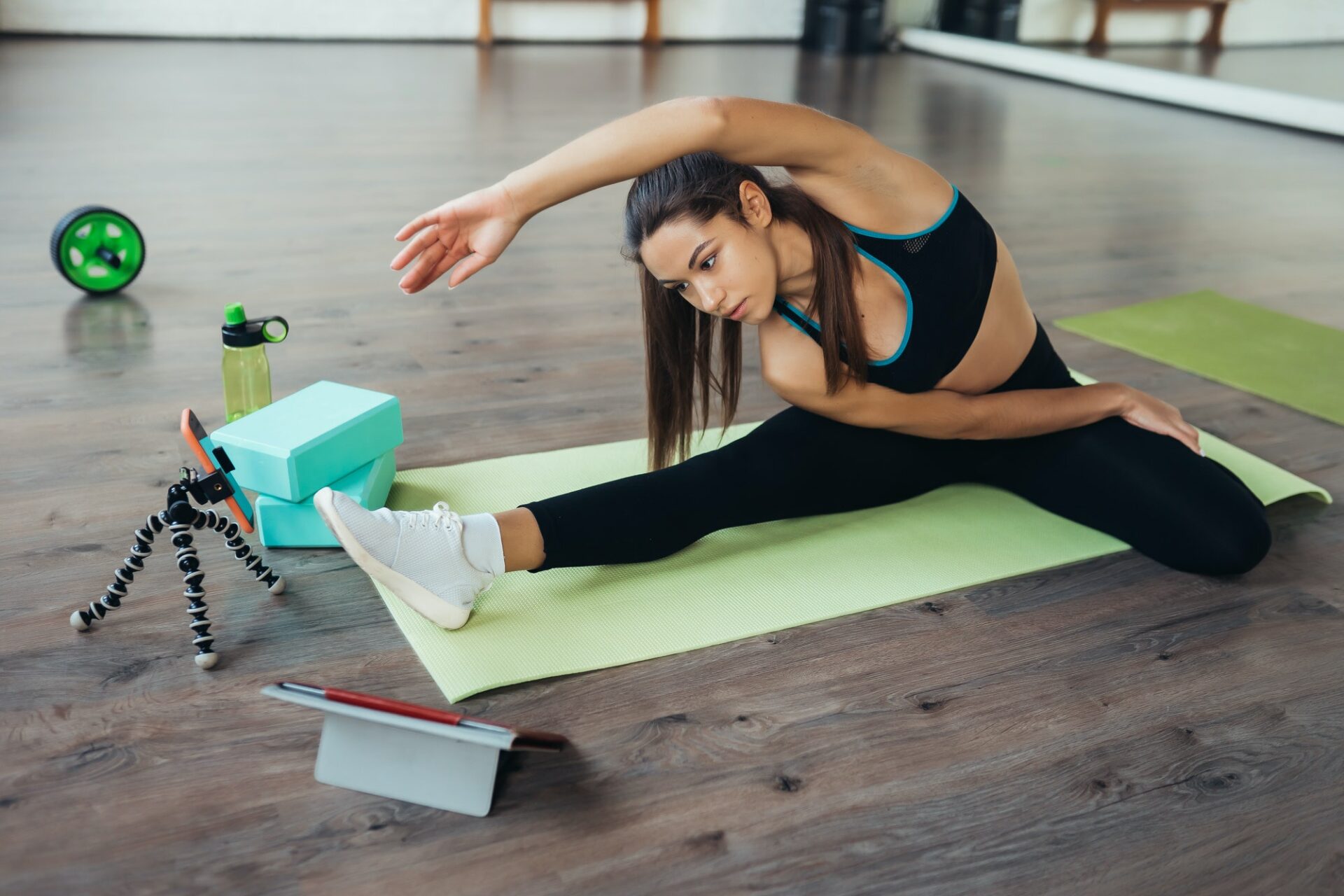 Young woman practicing yoga, is engaged with the teacher online